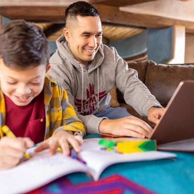 IMAGE DESCRIPTION A man using a laptop while seated next to a boy