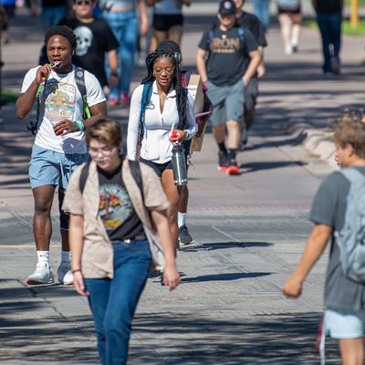 Crowd of students walking outside on campus