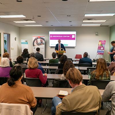 IMAGE DESCRIPTION A man speaking to a group of people in a room