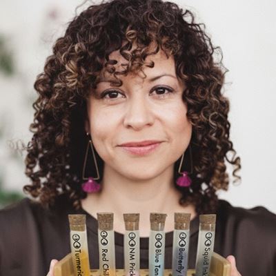 IMAGE DESCRIPTION A woman holding a small rack containing vials of liquid