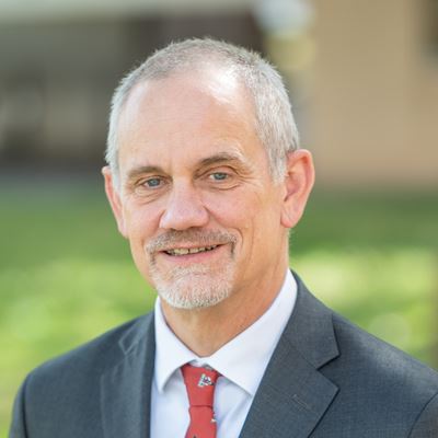 Portrait of NMSU President Valerio Ferme outdoors in grey suit