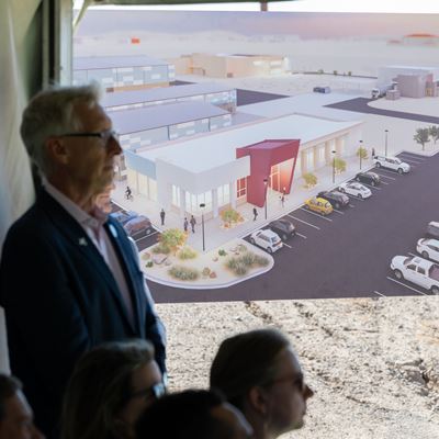 IMAGE DESCRIPTION A man standing in front of a poster of a building rendering