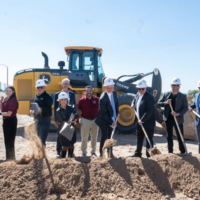 IMAGE DESCRIPTION A group of people wearing hardhats and holding shovels near a pile of dirt