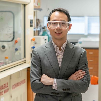 Man standing in a lab with his arms crossed