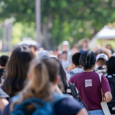 A crowd of university students walks to class on a fall day