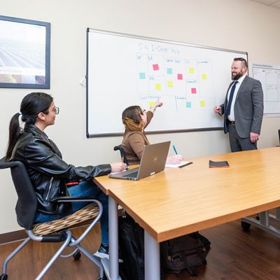 Photo of Kramer Winingham talks with students Faezeh Cheraghi Berenice Lopez and Caleb Foreman
