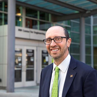 IMAGE DESCRIPTION A man in a suit standing outside of a building