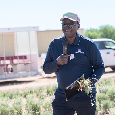 IMAGE DESCRIPTION A man standing in a field holding a microphone