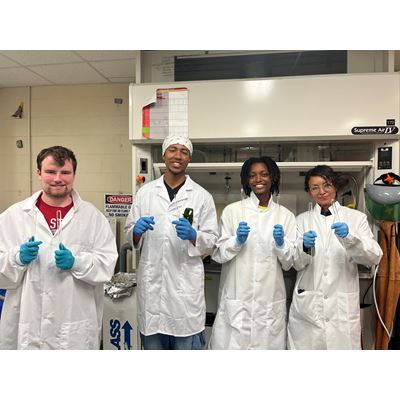 Description Four students attending New Mexico State University s NuChemE Pipeline summer initiative are holding up test tubes while in a lab