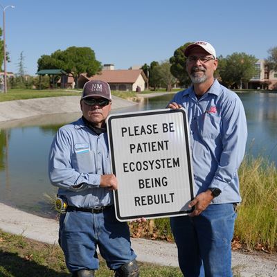 Photo of Facilities Services crew putting up signage at Alumni Pond