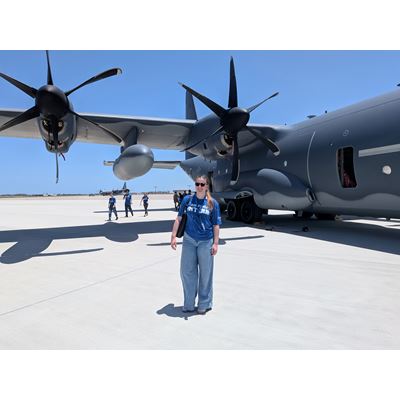 Description A woman stands in front of a plane