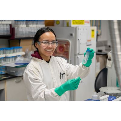 Description A researcher holds up two tubes with a liquid sample