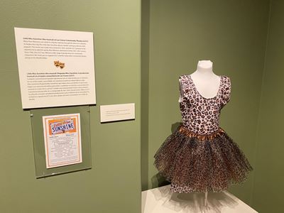 A bathing suit on a mannequin and program on a wall