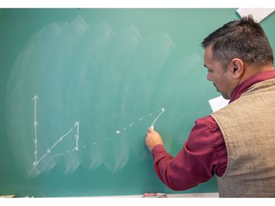 A man writing on a chalkboard