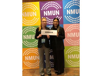 Two female students holding a sign