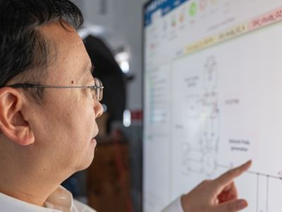 IMAGE DESCRIPTION Man standing next to a screen with diagrams
