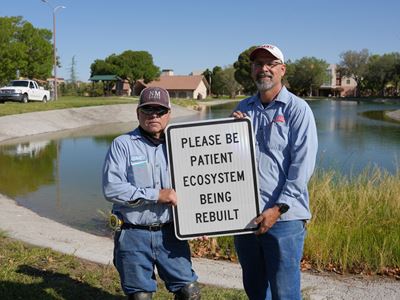 Photo of Facilities Services crew putting up signage at Alumni Pond