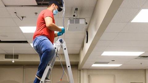Luis Tovar, of New Mexico State University’s Information and Communications Technologies, sets up a hybrid classroom on