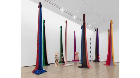 Different garments hanging on pillars in a room