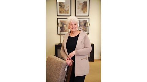 A woman leaning on a chair