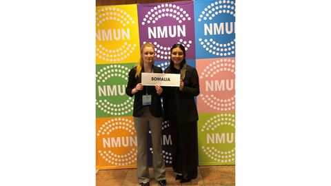 Two female students holding a sign