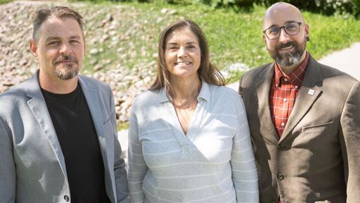 IMAGE DESCRIPTION Three people standing outdoors