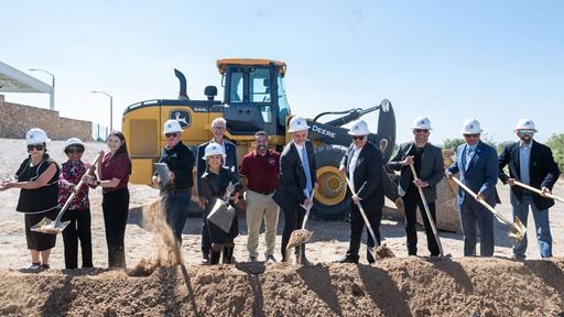 IMAGE DESCRIPTION A group of people wearing hardhats and holding shovels near a pile of dirt