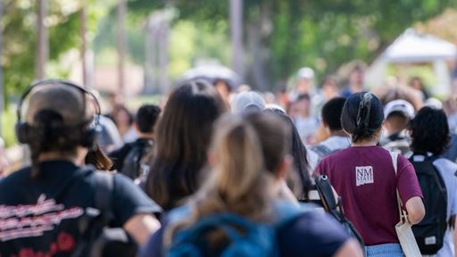 A crowd of university students walks to class on a fall day
