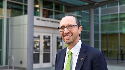 IMAGE DESCRIPTION A man in a suit standing outside of a building