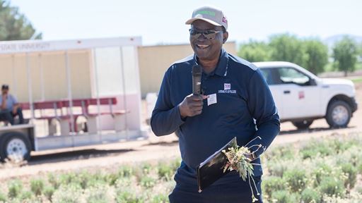 IMAGE DESCRIPTION A man standing in a field holding a microphone