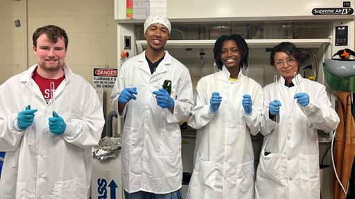 Description Four students attending New Mexico State University s NuChemE Pipeline summer initiative are holding up test tubes while in a lab