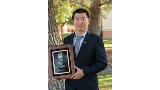 IMAGE DESCRIPTION Man standing outdoors holding a plaque