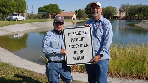Photo of Facilities Services crew putting up signage at Alumni Pond