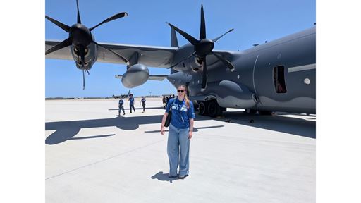 Description A woman stands in front of a plane