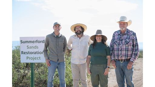 DESCRIPTION Three men and a woman standing by an outdoor sign that reads Summerford Sands Restoration Project