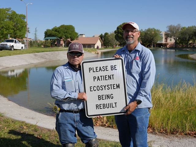 Photo of Facilities Services crew putting up signage at Alumni Pond