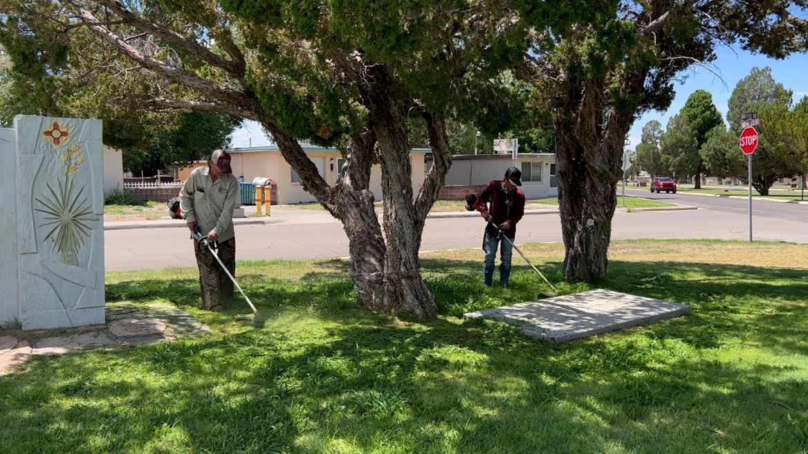 Grounds crew members maintaining weed control at Tom Fort Village