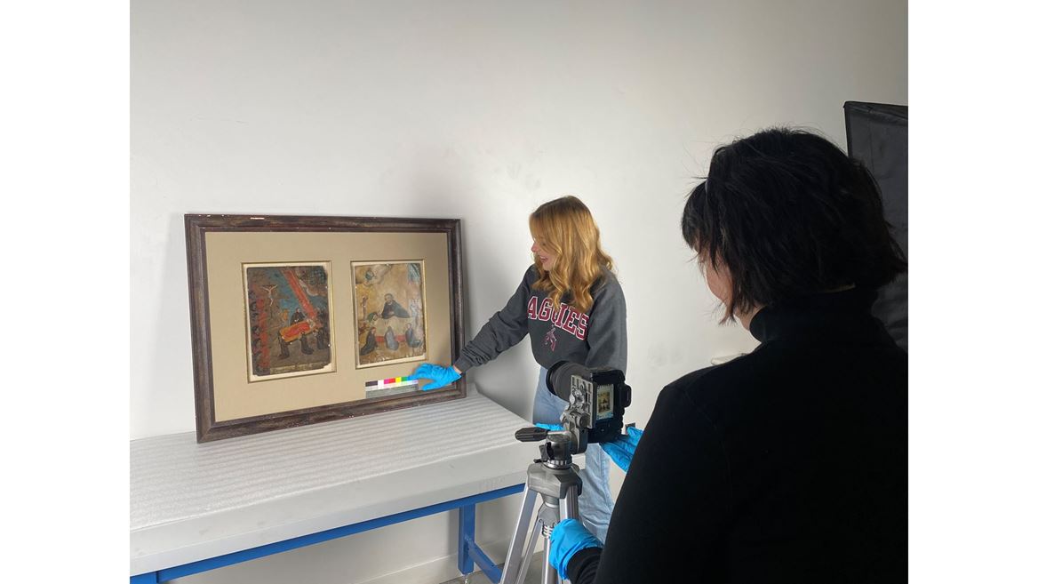 Two women taking photos of paintings