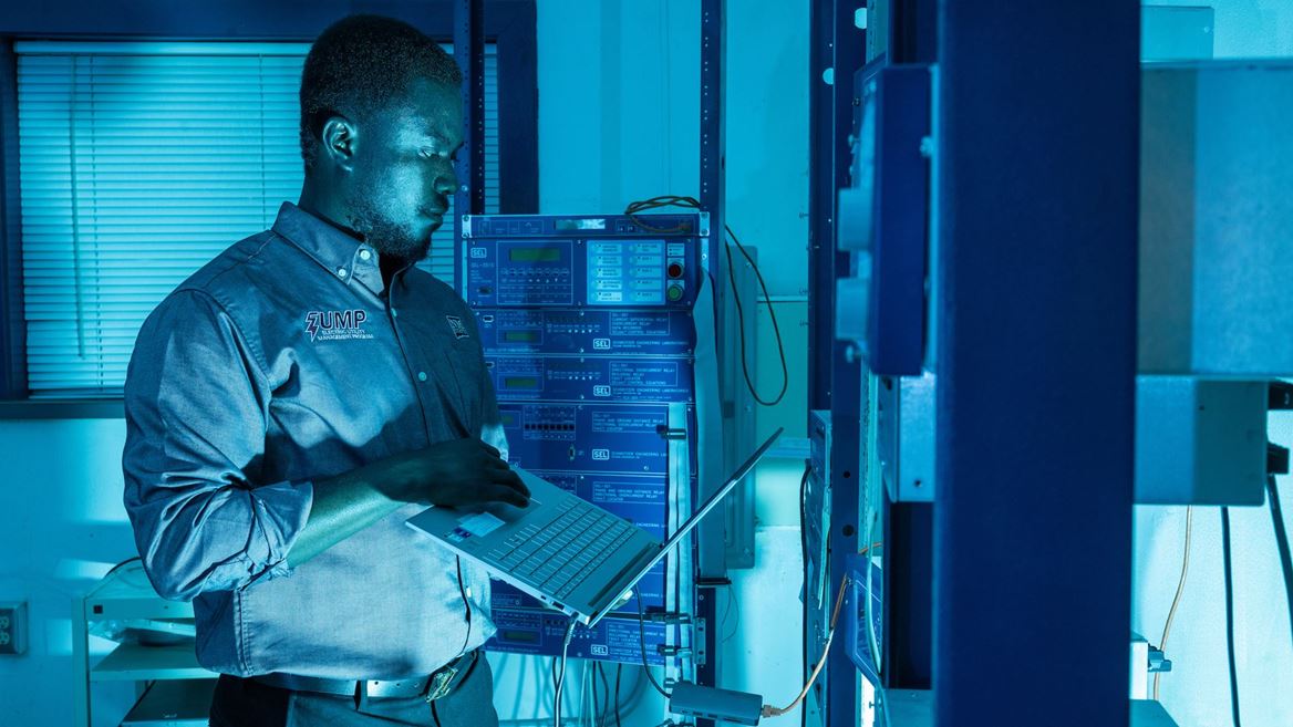 IMAGE DESCRIPTION Man standing next to electrical equipment
