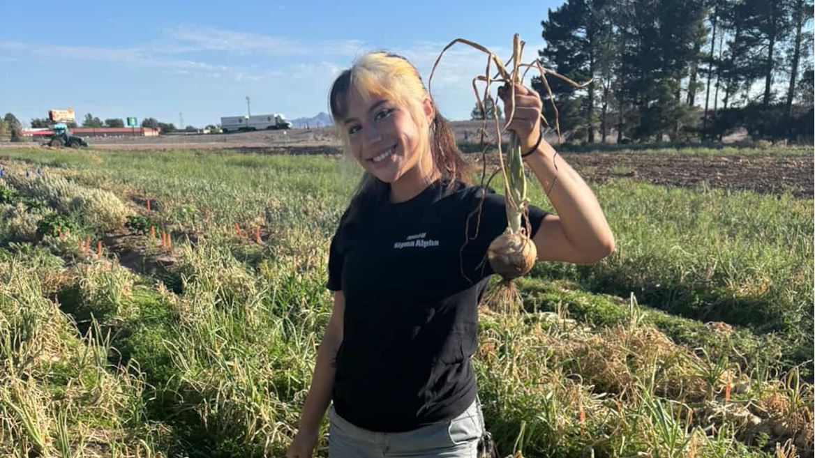 Photo of Alexis Olmos in the field with onion