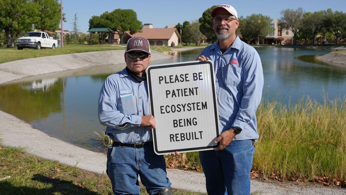 Photo of Facilities Services crew putting up signage at Alumni Pond