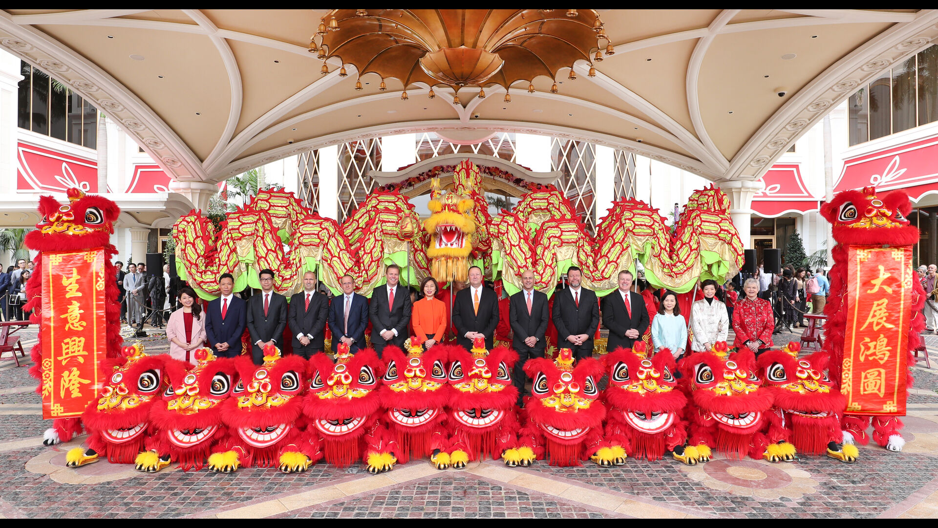 The Wynn management team poses for a group photo with colorful lions and dragons at Wynn Palace Cotai.
