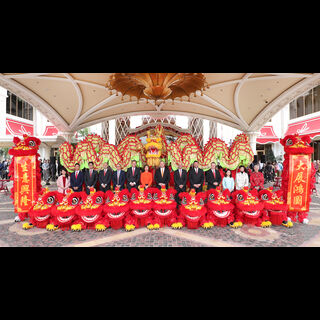 The Wynn management team poses for a group photo with colorful lions and dragons at Wynn Palace Cotai.