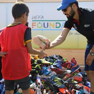 Children at the Zaatari Refugee Camp receive donated football boots from 2018/2019 season Trophy Tour Driven by Kia camp